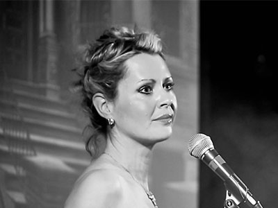 Joanna Appleby singing into a microphone
